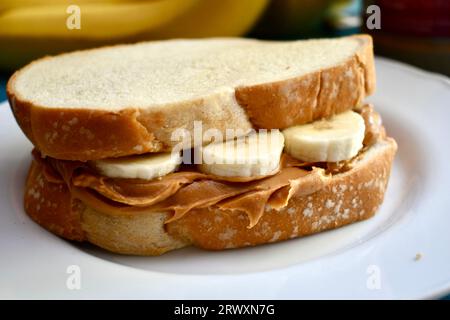 Sandwich au beurre d'arachide et à la banane sur une assiette blanche Banque D'Images