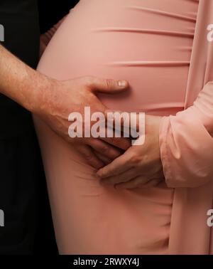 Mère et père embrassent la bosse de bébé de la mère Banque D'Images