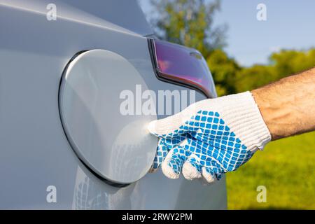 le conducteur ferme la trappe du réservoir de carburant. fermez le bouchon du réservoir de carburant à la main. remplissage de la voiture Banque D'Images