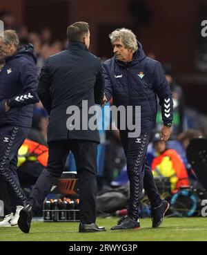 Le Manager des Rangers Michael Beale (à gauche) et l’entraîneur-chef du Real Betis Manuel Pellegrini serrent la main après le match du groupe C de l’UEFA Europa League au stade Ibrox, Glasgow. Date de la photo : jeudi 21 septembre 2023. Banque D'Images