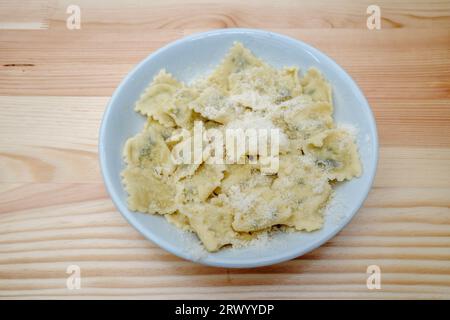 Vue de dessus et gros plan à Ravioli sur le dessus avec du fromage parmesan, sur la table en bois. Banque D'Images