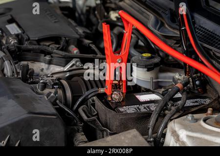 Démarrage d'appoint ou chargement de la batterie déchargée de la voiture. Concept d'entretien, de réparation et de service des véhicules. Banque D'Images