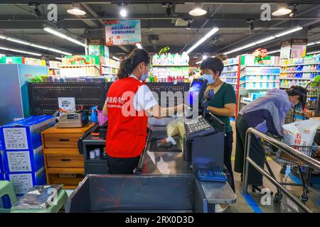 Comté de Luannan, Chine - 10 août 2023 : le caissier du supermarché charge. Banque D'Images
