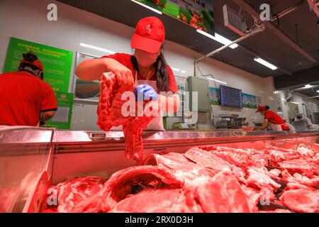 Comté de Luannan, Chine - 10 août 2023 : le personnel du supermarché organise des produits à base de viande. Banque D'Images