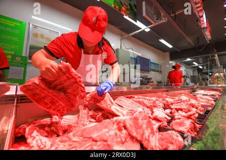 Comté de Luannan, Chine - 10 août 2023 : le personnel du supermarché organise des produits à base de viande. Banque D'Images