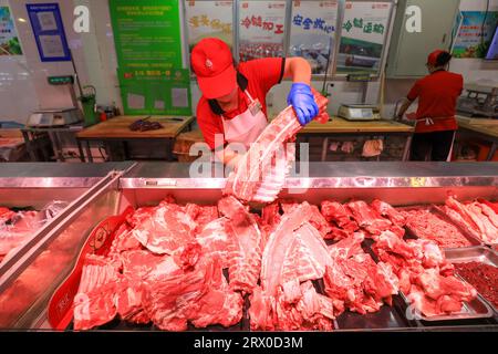 Comté de Luannan, Chine - 10 août 2023 : le personnel du supermarché organise des produits à base de viande. Banque D'Images