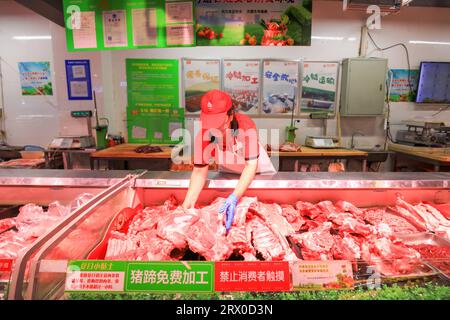 Comté de Luannan, Chine - 10 août 2023 : le personnel du supermarché organise des produits à base de viande. Banque D'Images