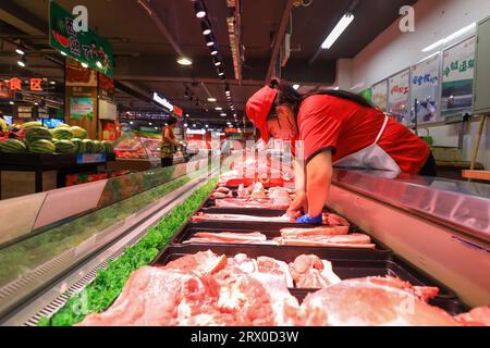 Comté de Luannan, Chine - 10 août 2023 : le personnel du supermarché organise des produits à base de viande. Banque D'Images