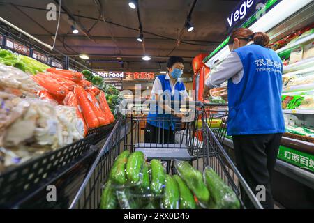 Comté de Luannan, Chine - 10 août 2023 : le personnel du supermarché organise divers produits. Banque D'Images