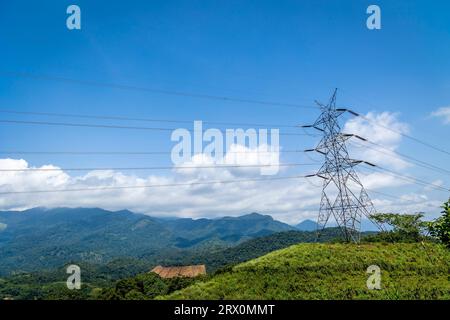 Alimentation à haute tension, lignes électriques courant le long du paysage de la vallée avec des montagnes en arrière-plan dans le Kerala Banque D'Images