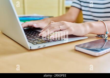 Gros plan des mains d'une jeune étudiante tapant sur un ordinateur portable Banque D'Images