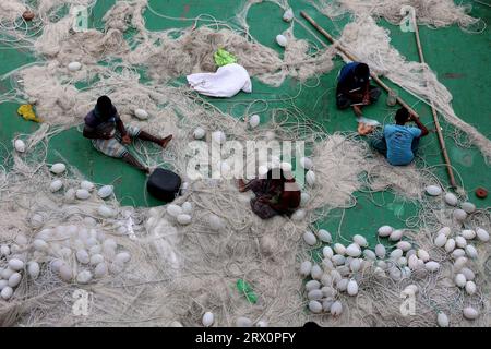 20 septembre 2023, Chittagong, rivière Karnaphuli, Bangladesh : pêcheurs occupés à réparer des filets pour aller pêcher en mer assis sur la drague de sable dans la rivière Karnaphuli de Chittagong, Bangladesh. (Image de crédit : © Mohammed Shajahan/ZUMA Press Wire) USAGE ÉDITORIAL SEULEMENT! Non destiné à UN USAGE commercial ! Banque D'Images