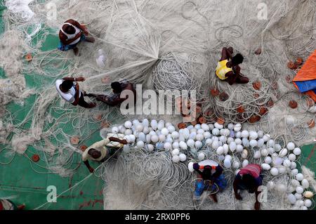 20 septembre 2023, Chittagong, rivière Karnaphuli, Bangladesh : pêcheurs occupés à réparer des filets pour aller pêcher en mer assis sur la drague de sable dans la rivière Karnaphuli de Chittagong, Bangladesh. (Image de crédit : © Mohammed Shajahan/ZUMA Press Wire) USAGE ÉDITORIAL SEULEMENT! Non destiné à UN USAGE commercial ! Banque D'Images