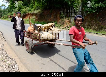 Hommes malgaches transportant du matériel et des marchandises sur une charrette. Banque D'Images