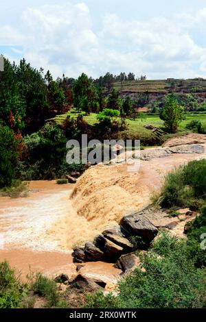 Une rivière boueuse le long de la route RN2 dans le centre de Madagascar. Banque D'Images