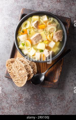 Soupe Kottsoppa finlandaise et suédoise avec bœuf, pommes de terre, carottes, poireaux, céleri et panais en gros plan dans une assiette sur la table. Vue verticale de dessus depuis ab Banque D'Images