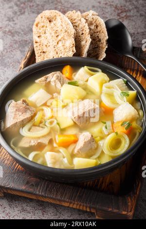 Le Kottsoppa est une soupe claire de viande et de légumes-racines consommée en Suède et en Finlande en gros plan sur une assiette sur la table. Vertical Banque D'Images