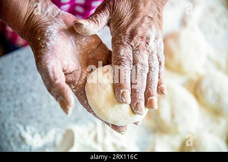 Cuit la pâte pour la cuisson, morceaux de pâte crue. Pâte à gâteaux faits maison dans les mains des femmes. Procédé de fabrication de tartes, à la main. Mains pâte à tarte. Les mains des femmes Banque D'Images