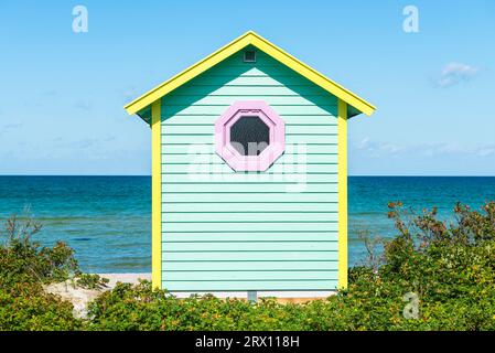 Vue frontale de l'arrière d'une cabane en bois turqoise jaune sur la plage de Skanör med Falsterbo au Öresund au soleil du matin, Skåne, Suède Banque D'Images