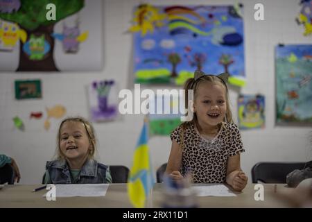 Kramatorsk, Ukraine. 19 septembre 2023. Dasha (r), 5 ans, rit pendant les cours au « Tato Hub » à Kramatorsk, un établissement géré par des bénévoles pour les enfants restés dans la zone de guerre. De nombreux enfants viennent de localités qui sont des points chauds de la guerre. Leurs familles se sont sauvées des combats dans la petite ville de Kramatorsk. (Pour dpa 'le Hub de Tato veut stabiliser l'âme des enfants blessés en Ukraine') crédit : Oliver Weiken/dpa/Alamy Live News Banque D'Images