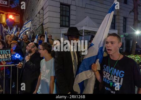 Un jeune homme tenant un drapeau israélien prend part à une opposition à la manifestation de réforme judiciaire en face de l'hôtel du Premier ministre Benjamin Netanyahu, le Lowe Regency sur Park Avenue. Deux contre-manifestations ont eu lieu en face de l'hôtel du Premier ministre Netanyahu, le Lowe Regency sur Park Avenue, avant son discours vendredi matin à l'Assemblée générale des Nations Unies pour le rassemblement annuel des dirigeants mondiaux. Un petit groupe de personnes, principalement des Juifs américains, était en faveur du Premier ministre Netanyahu, tandis qu’un groupe beaucoup plus important, principalement des expatriés israéliens, était en opposition à la réforme judiciaire. Banque D'Images