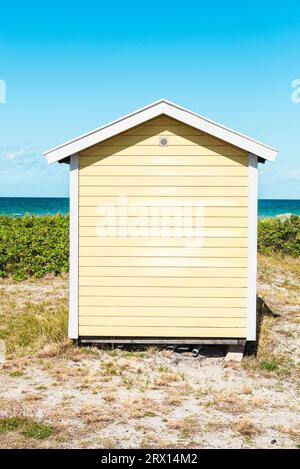 Vue frontale de l'arrière d'une cabane en bois jaune sur la plage de Skanör med Falsterbo à la Öresund au soleil du matin, Skåne, Suède Banque D'Images