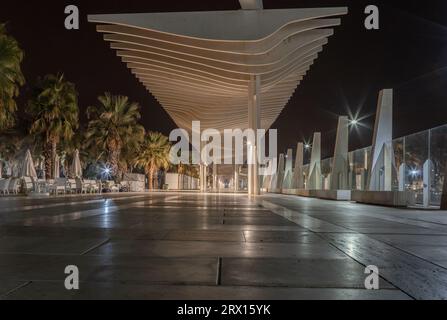 Promenade publique à Malaga, Parmeral de las Sorpresas à la fin de la nuit dans les couleurs des lumières nocturnes de la ville. Architecture urbaine moderne, Malaga. Banque D'Images