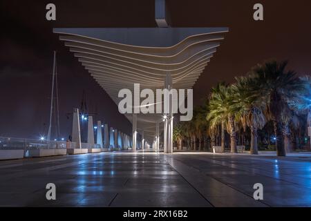 Promenade publique à Malaga, Parmeral de las Sorpresas à la fin de la nuit dans les couleurs des lumières nocturnes de la ville. Architecture urbaine moderne, Malaga. Banque D'Images