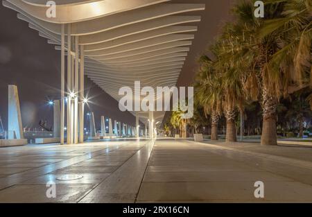 Promenade publique à Malaga, Parmeral de las Sorpresas à la fin de la nuit dans les couleurs des lumières nocturnes de la ville. Architecture urbaine moderne, Malaga. Banque D'Images