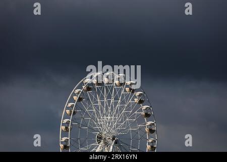 22 septembre 2023, Mecklembourg-Poméranie occidentale, Warnemünde : sur la côte Baltique, des nuages sombres passent au-dessus de la grande roue. Les jours estivaux sont terminés pour le moment. Photo : Bernd Wüstneck/dpa Banque D'Images