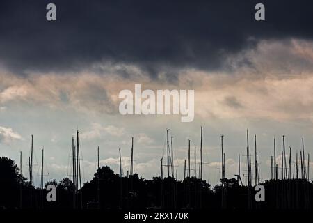 22 septembre 2023, Mecklembourg-Poméranie occidentale, Warnemünde : des nuages sombres se rassemblent au-dessus des mâts des voiliers sur la côte Baltique. Les jours estivaux sont terminés pour le moment. Photo : Bernd Wüstneck/dpa Banque D'Images