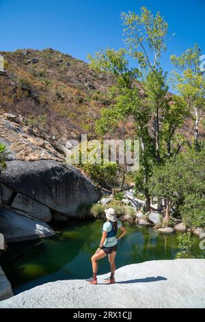 Femme debout sur un rocher à une source dans la Sierra de la Laguna Banque D'Images