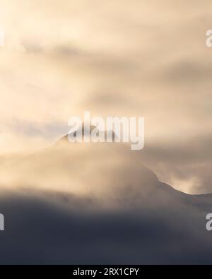 Un pic de montagne couvert de nuages et de soleil Banque D'Images