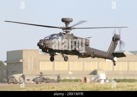 Army Air corps WAH-64D Apache menant une formation de vol stationnaire au-dessus de l'herbe fraîchement coupée à l'aérodrome de Wattisham. Banque D'Images