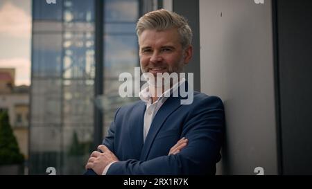 Portrait d'affaires en plein air employeur d'affaires aux cheveux gris posant dans la ville un homme d'affaires caucasien d'âge moyen homme d'affaires croisé les mains croisant les bras près de l'entreprise Banque D'Images
