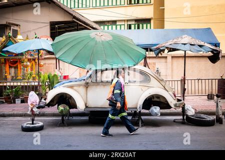 Une très vieille voiture Volkswagen Beetle en ruine se trouve sous des parapluies dans la région de China Town à Bangkok, en Thaïlande. Banque D'Images