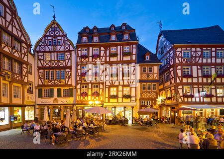 Maisons à colombages à pignons sur la place du marché médiéval animée le soir, Bernkastel-Kues, Rhénanie-Palatinat, Allemagne Banque D'Images