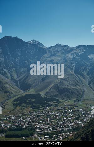 Vue sur le village de Stepantsminda, Kazbegi du sommet de la montagne. Une journée d'été ensoleillée. Un point de vue populaire parmi les touristes en Géorgie Banque D'Images