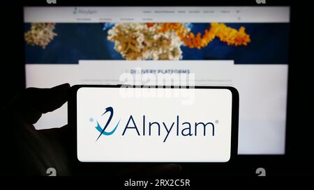 Personne tenant un smartphone avec le logo de la société américaine Alnylam Pharmaceuticals Inc. Sur l'écran devant le site Web. Concentrez-vous sur l'affichage du téléphone. Banque D'Images