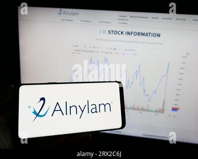 Personne tenant un téléphone mobile avec le logo de la société américaine Alnylam Pharmaceuticals Inc. Sur l'écran devant la page Web. Concentrez-vous sur l'affichage du téléphone. Banque D'Images