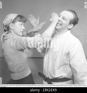 Dans les années 1950 Une jeune femme qui assiste à un cours d'autodéfense et surprend le trayeur étant un apprenant rapide, elle se défend avec sa main gauche et obtient un bon coup sur son visage et le nez, avec lui visiblement dans la douleur. Suède 1951. Photo Kristoffersson Ref BD37-3 Banque D'Images