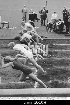 Le début d'une compétition de course à pied. Six femmes en compétition sont vues dès le moment de départ, prenant les premiers pas puissants dans la course du 100 mètres. Suède 1957 Banque D'Images