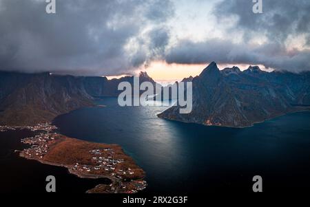 Nuages de tempête au coucher du soleil sur des montagnes majestueuses le long d'un fjord, vue aérienne, Baie Reine, Îles Lofoten, Nordland, Norvège, Scandinavie, Europe Banque D'Images