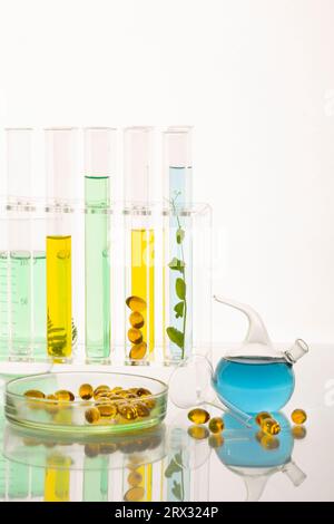 Tubes à essai avec des plantes dans un support, vitamines sur un fond clair, laboratoire. Banque D'Images Tubes à essai avec des plantes dans un support, vitamines sur un fond clair, laboratoire. Banque D'Images