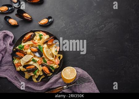 Vongole Spaghetti Italien, pâtes aux fruits de mer avec les palourdes et moules, dans la plaque avec des herbes sur l'arrière-plan en pierre rustique. Une cuisine italienne traditionnelle, clos de la mer Banque D'Images
