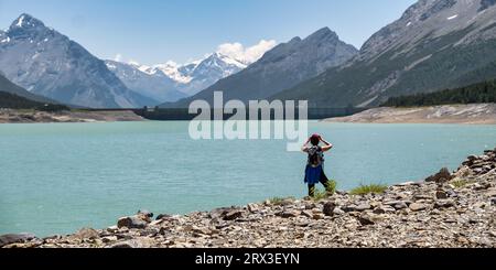 Jeune femme regardant le lac artificiel et les bassins d'eau. Lac Cancano et le lac supérieur de San Giacomo à environ 1900 mètres au-dessus du niveau de la mer dans le S. Banque D'Images