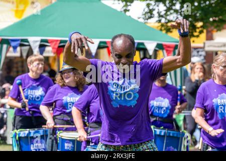 Danny Henry, artiste de danse noire, danse au rythme du groupe de tambours Batida Rio Samba lors de la Journée de sensibilisation au handicap 2023 à Warrington Banque D'Images