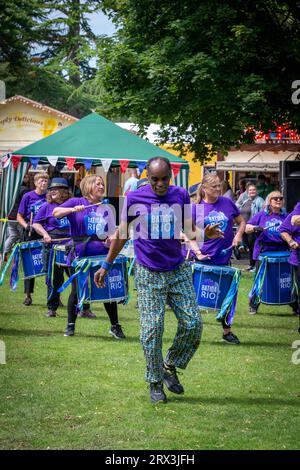 Danny Henry, artiste de danse noire, danse au rythme du groupe de tambours Batida Rio Samba lors de la Journée de sensibilisation au handicap 2023 à Warrington Banque D'Images