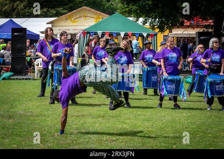 Danny Henry, artiste de danse noire, danse au rythme du groupe de tambours Batida Rio Samba lors de la Journée de sensibilisation au handicap 2023 à Warrington Banque D'Images