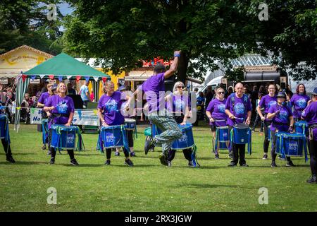 Danny Henry, artiste de danse noire, danse au rythme du groupe de tambours Batida Rio Samba lors de la Journée de sensibilisation au handicap 2023 à Warrington Banque D'Images